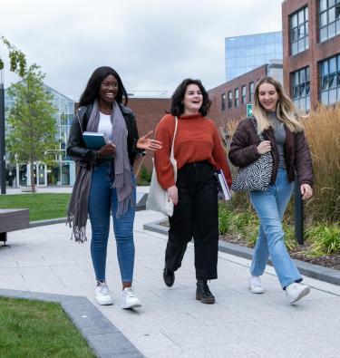 Photo of three students walking on campus