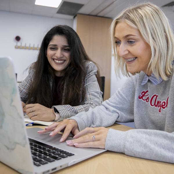 Shows two DCU female students in front of laptop