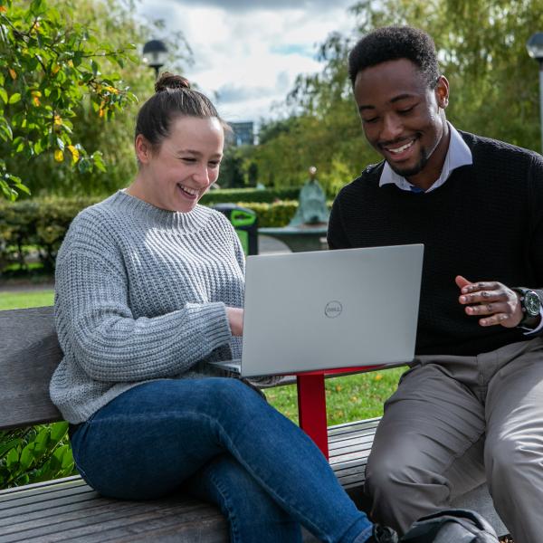 Shows two students with laptop on DCU's Glasnevin campus 