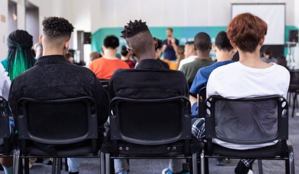 The backs of students sitting in class