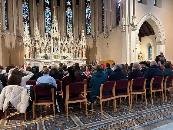 A group of people sitting in chairs in a churchDescription automatically generated