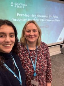 Two researchers in front of a screen at a conference 