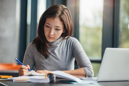 Student studying at home with a laptop