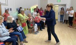 Coordinator hands award certificate to participant.