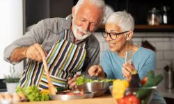 two older people are cooking together