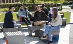 A group of international students sitting outside DCU in the sun