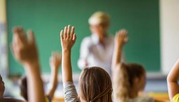 Childrens' raised hands in classroom