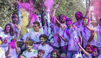 Student pictured with holi powdered colours on face