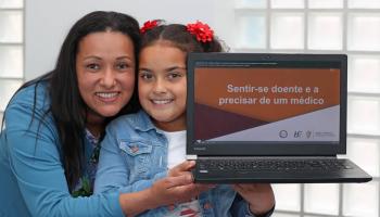  woman and child holding a laptop.