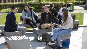 A group of international students sitting outside DCU in the sun
