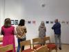 4 people examine prints on a wall