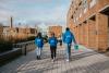 A group of student ambassadors in blue jackets walk down DCU Glasnevin campus.