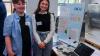 Students pose for a picture beside their project