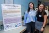 Students stand beside their poster at Expo