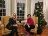 Shows two women sitting on chairs facing the camera