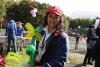 a girl is holding a balloon figure in a park