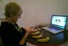 a woman is plugging cables into some bananas in front of her computer, she is smiling