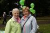 ladies posing in front of some green balloons