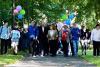 a group of people walking across campus with balloons