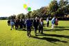 a group of people walking across campus with balloons