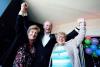 a group older people raising their arms and smiling