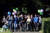 a group of people walking across campus with balloons