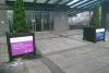 picture of the outside of DCU campus, two potted plants that have the poster for the conference on them