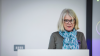 a woman speaks from a lectern