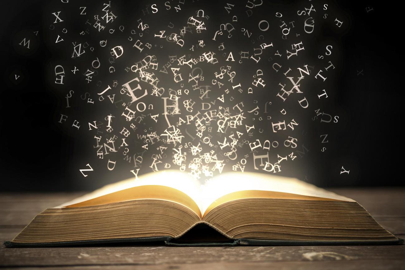 Open books with words flying into the air