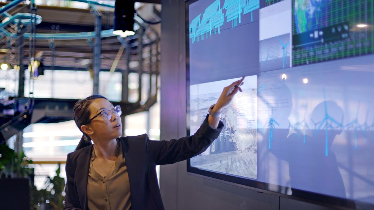 Woman pointing to data on digital screen