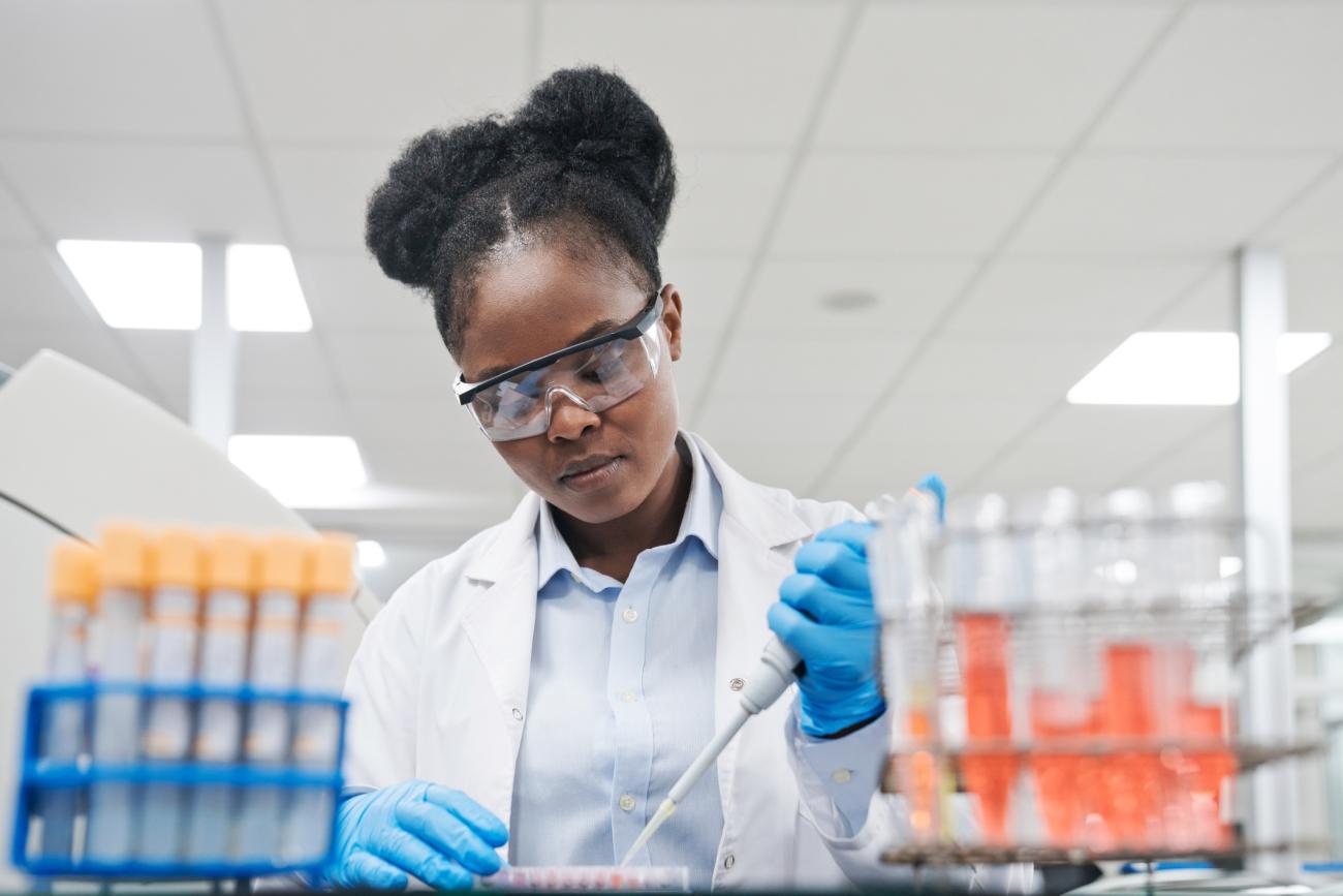 Student in lab coat working with pipette and samples