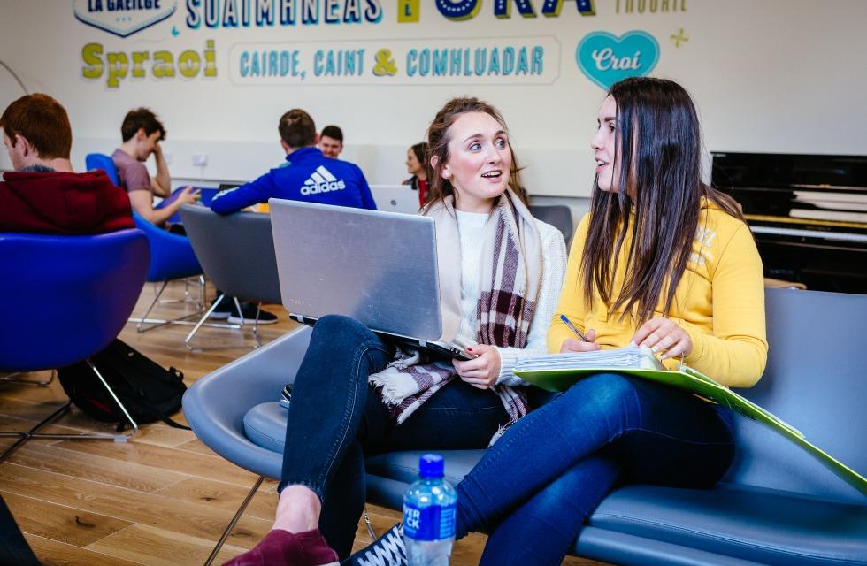 This photo shows two female students sitting and talking to each other