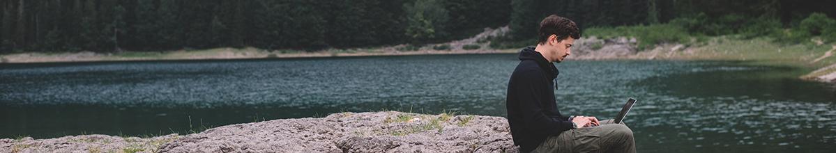 Header image - man using laptop in nature