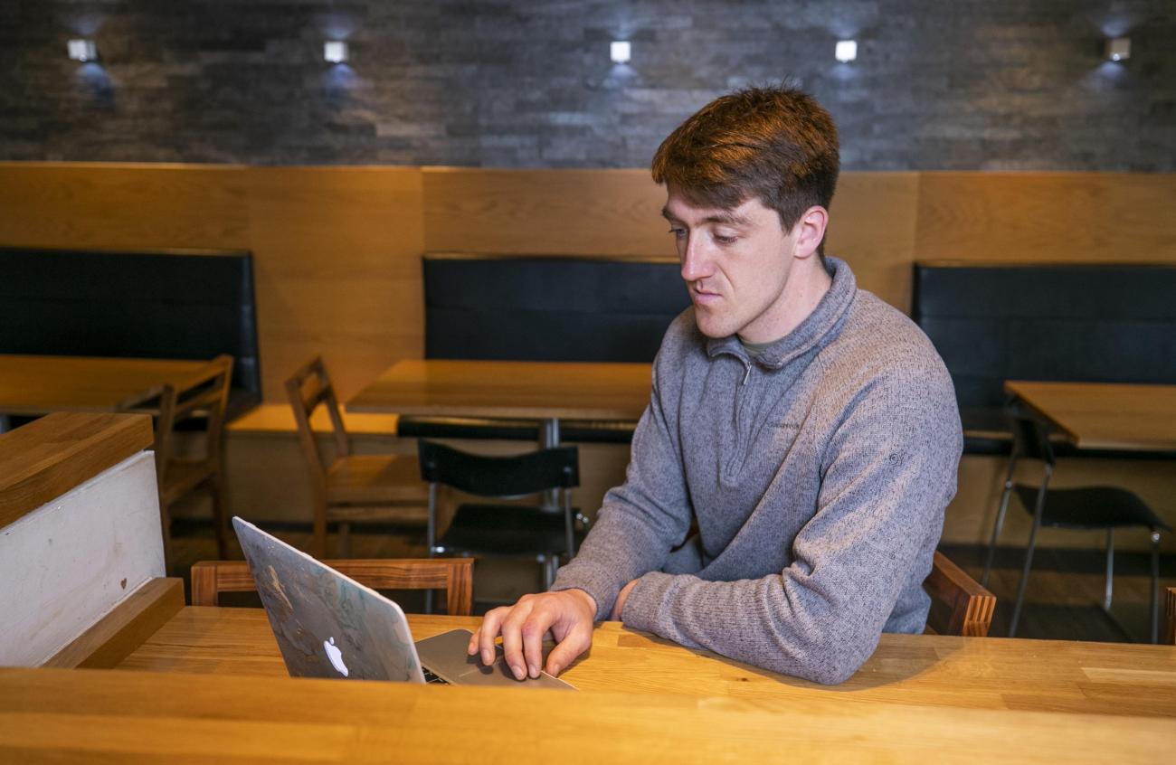 Shows student working on laptop