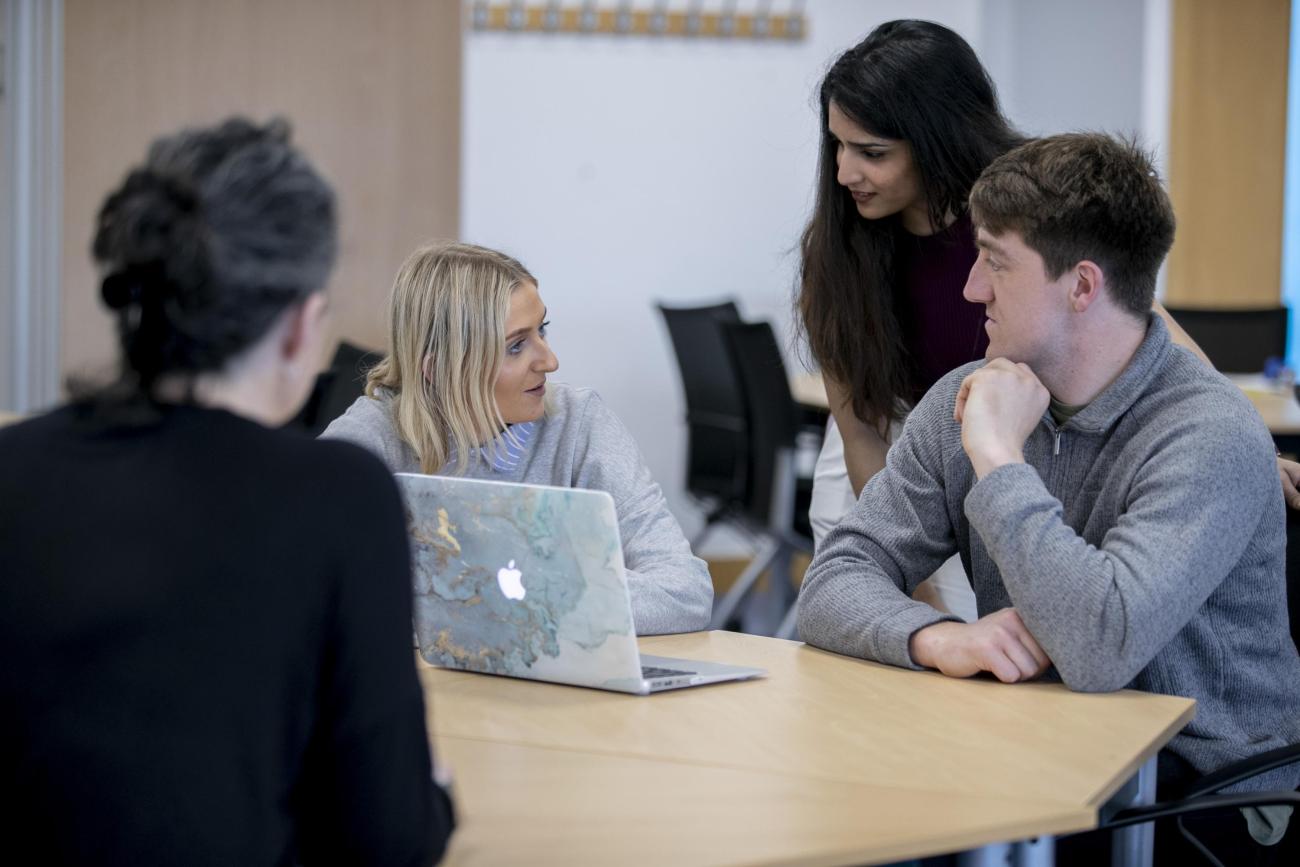 Shows four students in discussion