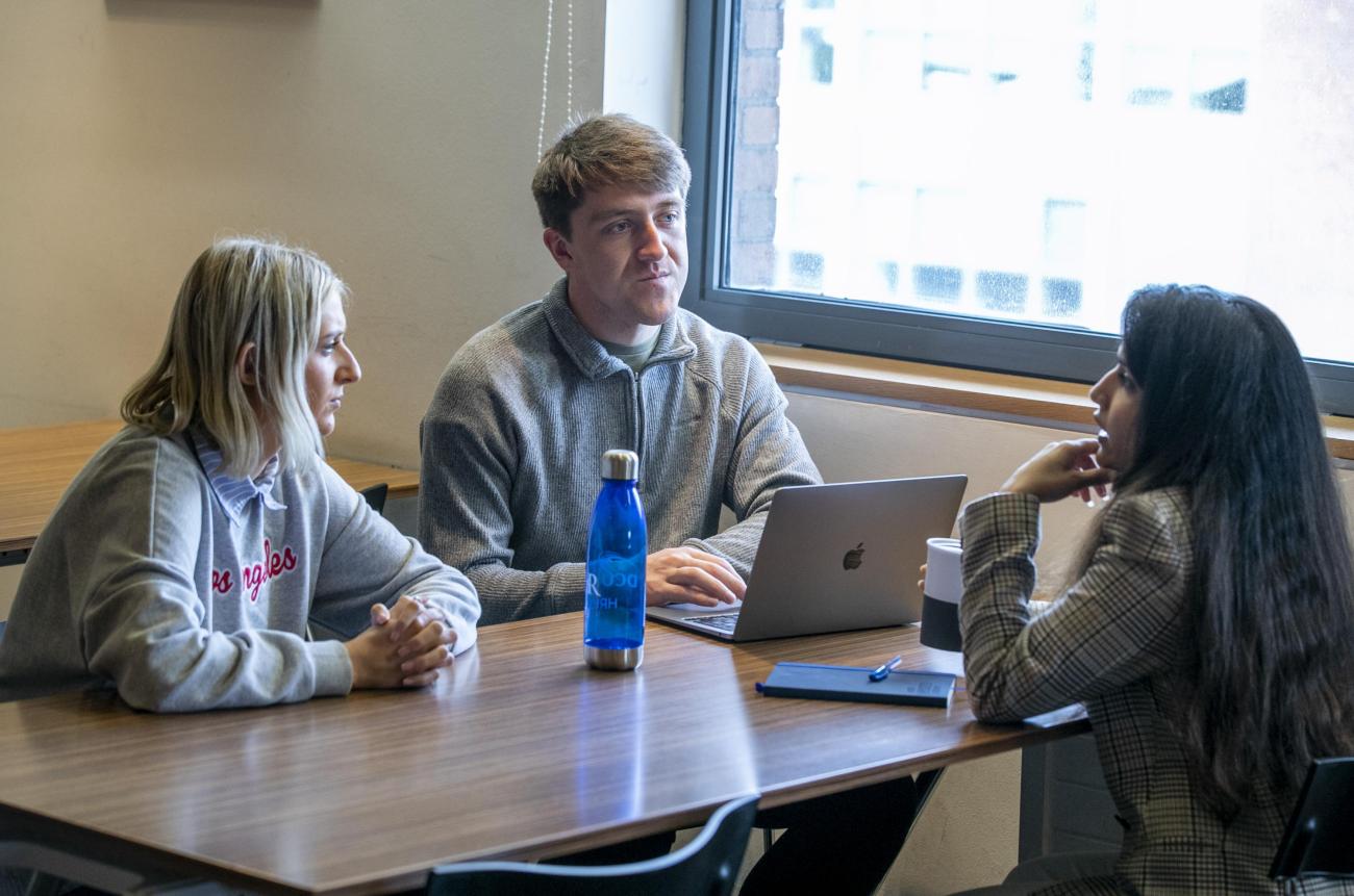 Shows three students chatting on DCU campus 