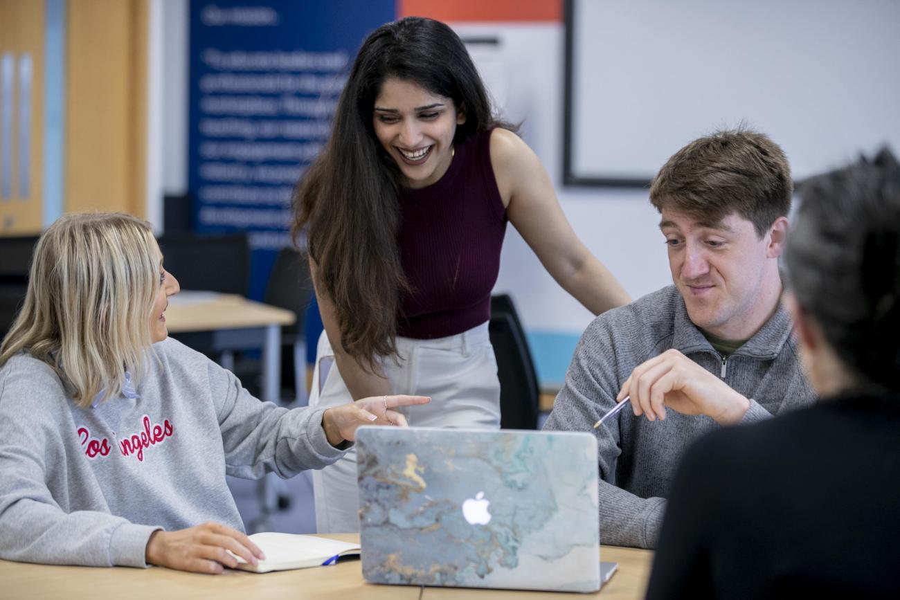 Shows three students holding discussions 