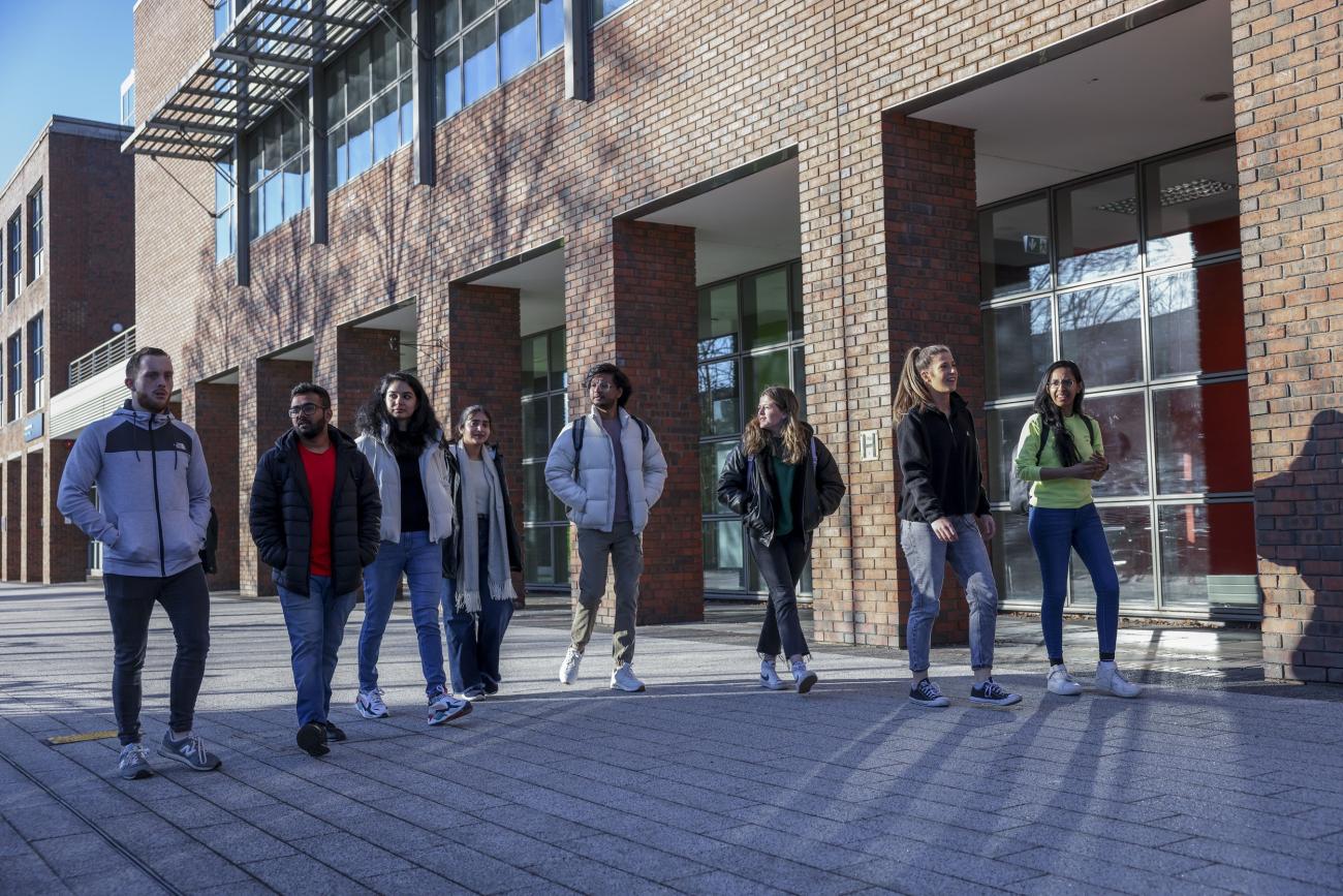 Shows a groupg of Postgraduage Engineering students walking on DCU's Glasnevin campus