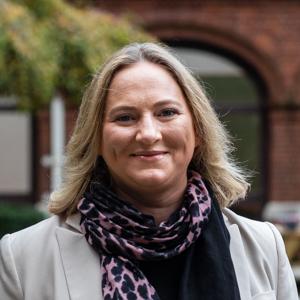 Picture of a woman with leafy campus in background