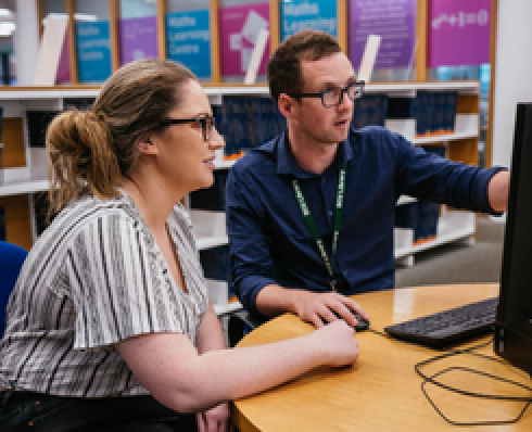 student sitting at PC consulting with subject librarian