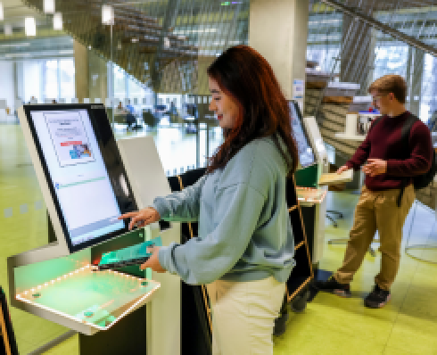 stduent returning book at self service machine