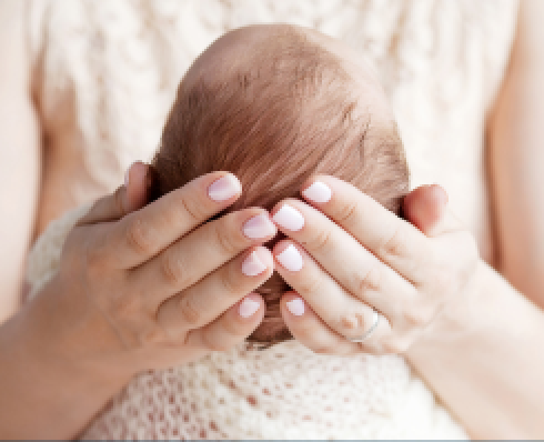 Shows hands holding a baby