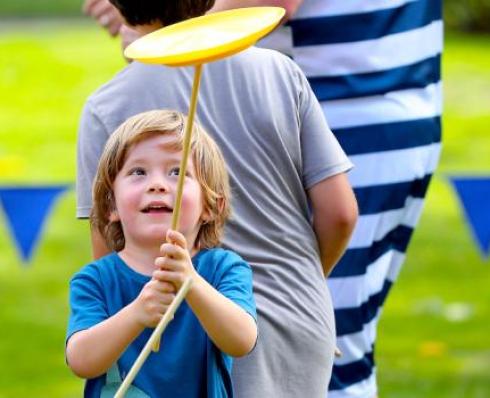 Child spinning a plate on a stick