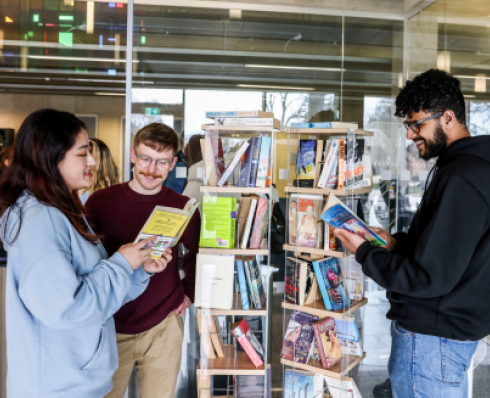 students browsing a shlef of fiction books