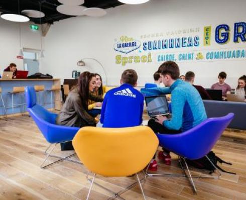 white room with students gathered and talking