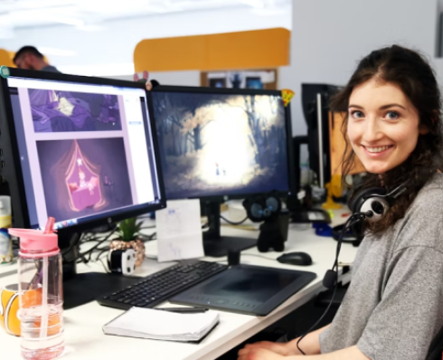 Animator Fiona Ryan sitting in front of a computer displaying her artwork