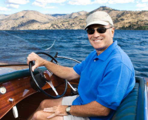 A smiling man driving a boat