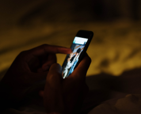Hands holding a phone in a dark room