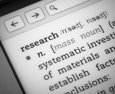 close up on laptop with definition of research on the screen