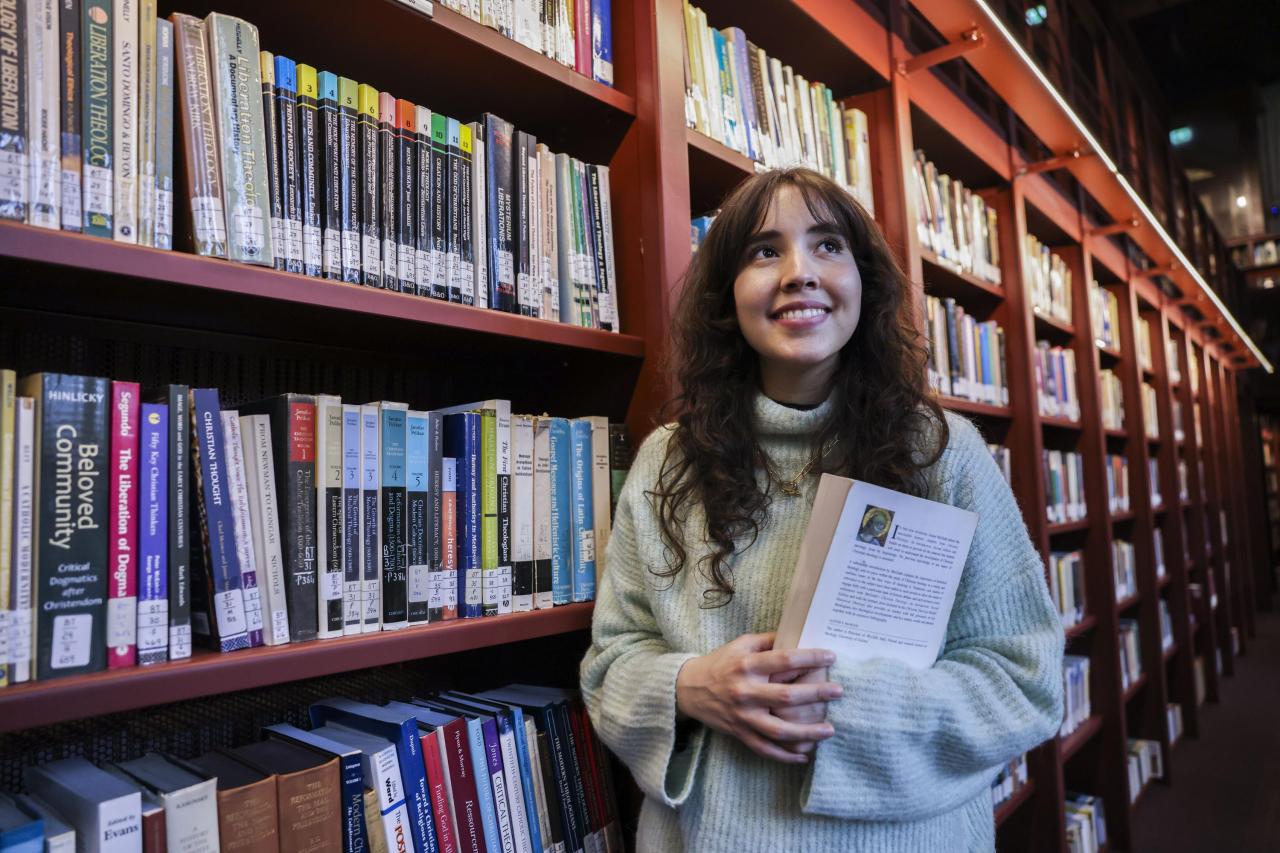 Student holding a book in the library
